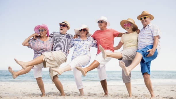 Happy senior friends dancing on the beach